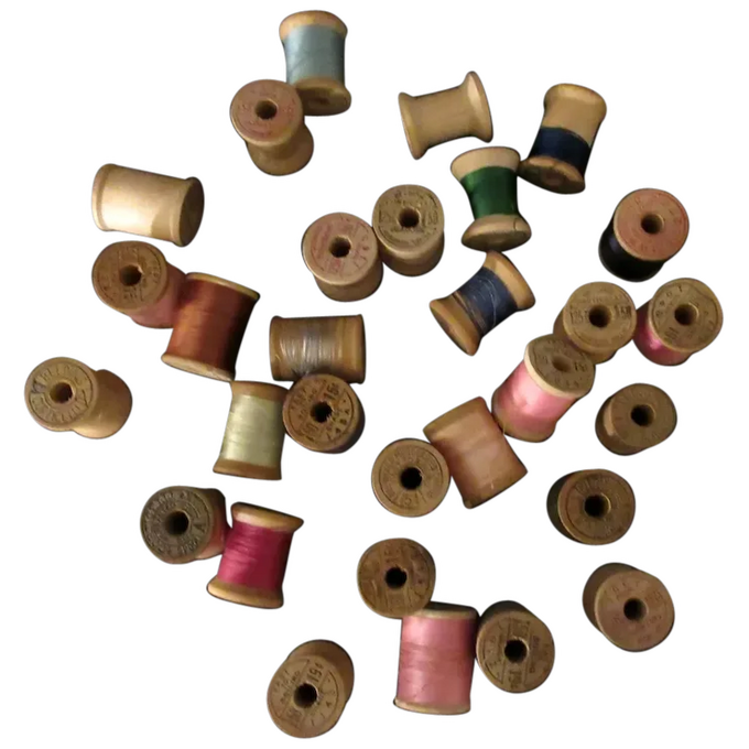 An assortment of spools of thread some lying on their sides and some sitting upright.